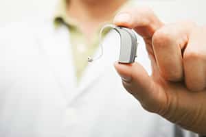 Audiologist holding hearing aid in Meriden, CT