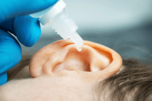 Child cleaning ear with peroxide