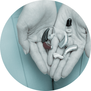 Person holding hearing aids in their hands